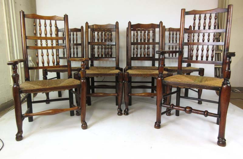 A harlequin set of eight (6+2) early 20th century elm spindle back dining chairs with rush seats, h.