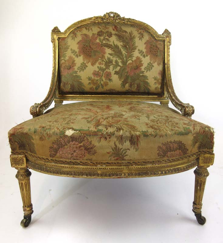 A late 18th century giltwood bedroom chair upholstered in a floral silk fabric with swag,