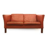 A 1970's red leather two seater sofa on stained beech legs CONDITION REPORT: Wear.