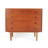 A 1960/70's Danish teak chest of four long drawers with integral turned handles on tapering legs by