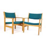 A pair of Hans Wegner designed oak armchairs with blue fabric upholstery