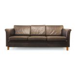 A 1970's black leather three seater sofa on beech legs with open arms