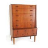 A 1970's teak secretaire with a staggered front, an arrangement of ten drawers,