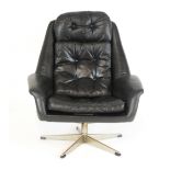 A 1970's Danish lounge armchair with black button upholstery on a five-star swivel base by Bramin