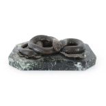 An Art Deco brown patinated desk piece modelled as an entwined snake, on a marble plinth, w.