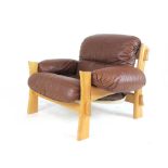 A 1970's lounge armchair with an exposed oak frame and brown leather upholstery