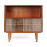 A 1970's teak bookcase, the bottom two shelves enclosed by a pair of striped glass doors,