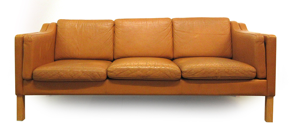 A 1970's tan leather three seater sofa on beech legs,