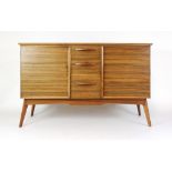 An Alfred Cox walnut finished sideboard, the three drawers flanked by a pair of doors,