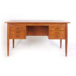 A 1970's teak desk with six drawers on circular tapering legs, w.