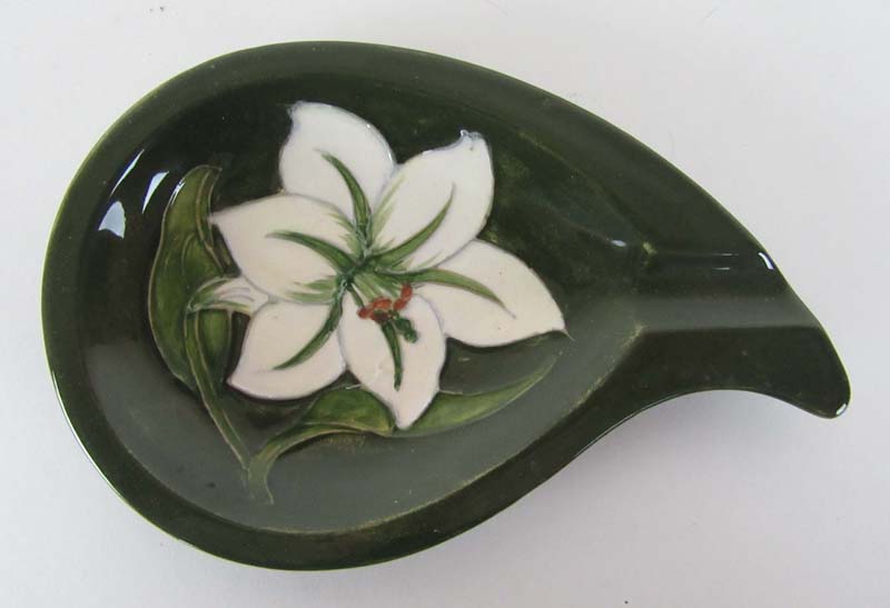 A Moorcroft 'Bermuda Lily' ashtray of tear drop form, decorated on a green ground. L.