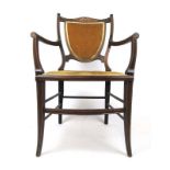 An Edwardian mahogany, marquetry and ivorine strung open arm chair upholstered in a gold cut fabric,