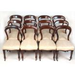 A set of twelve Victorian mahogany balloon back dining chairs upholstered in a patterned white gold