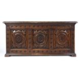A reproduction oak coffer, the three panel top and front with Elizabethan style carving, h.