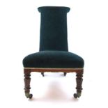 A Victorian simulated rosewood prie dieu upholstered in a cut green fabric on turned legs and brass