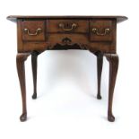 An 18th century oak low boy, the moulded top over three drawers and shaped frieze on cabriole legs,