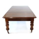 A Victorian oak extending table with three fitted leaves on turned supports and castors, max l.