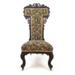 A Victorian rosewood prie dieu upholstered in a florally patterned fabric,