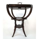 An Edwardian mahogany tray table with removable glass bottomed galleried tray on four C-scroll