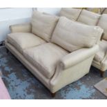 SOFA, two seater, in beige fabric on square supports with castors, 178cm L.