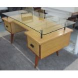 DESK, circa 1950's / 1960's with a raised glass top and two deep drawers below on tapered supports,