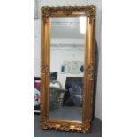 MIRROR, bevelled in an ornate gilded frame, 194cm x 85cm.