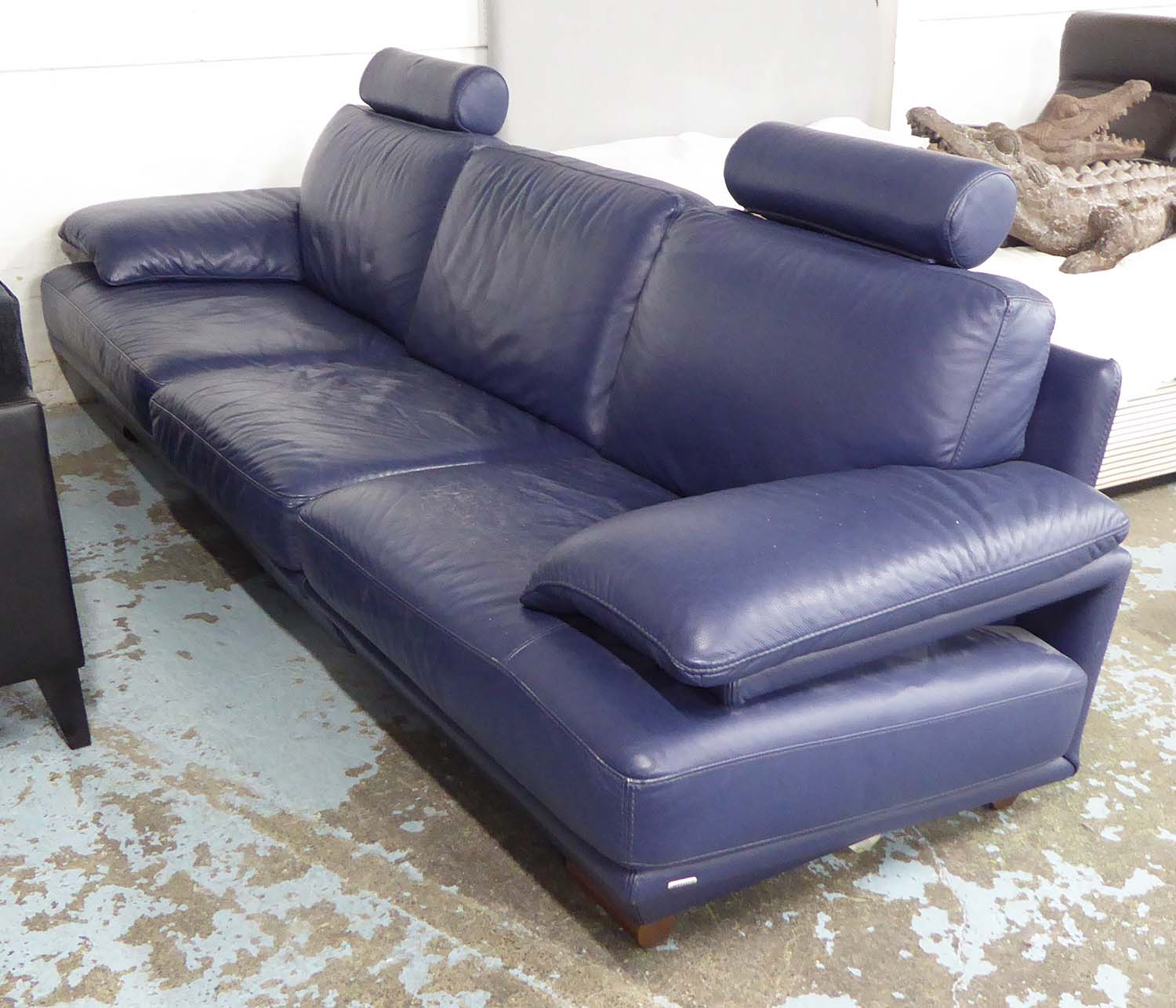 NATUZZI SOFA, navy blue leather in two sections, 93cm x 83cm H x 283cm L.