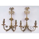 WALL APPLIQUES, a pair, gilt brass, each with twin lighting arms, foliate and ribbon cast detail,