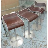 BAR STOOLS, a set of four, with wooden shaped seats on a metal swivel frame, 36cm W.