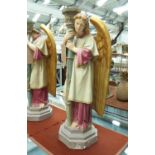 ANGEL CANDLE HOLDERS, a pair, plaster, in pastel colours, 70cm H.