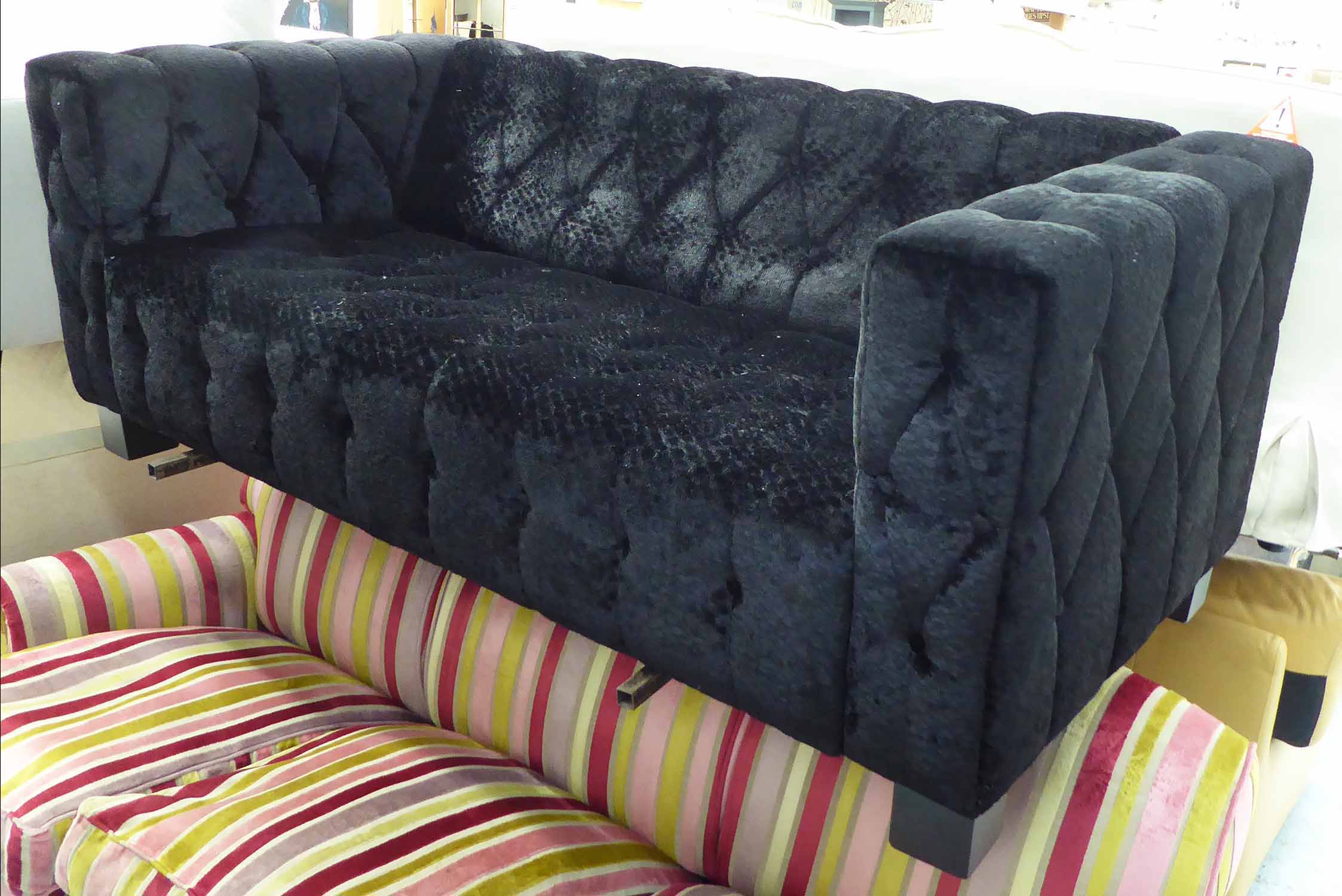 SOFA, two seater, in buttoned black fabric on square supports, 179cm L.