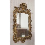 GILTWOOD WALL MIRROR, George III manner, the florid frame with flower basket cresting,