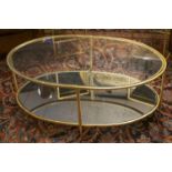 LOW OCCASIONAL TABLE, gilt metal framed, two tier, with an oval glass top and a mirrored undertier,