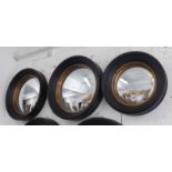 CONVEX WALL MIRRORS, a pair, Regency style, moulded black surround with gilt trim plus one other,