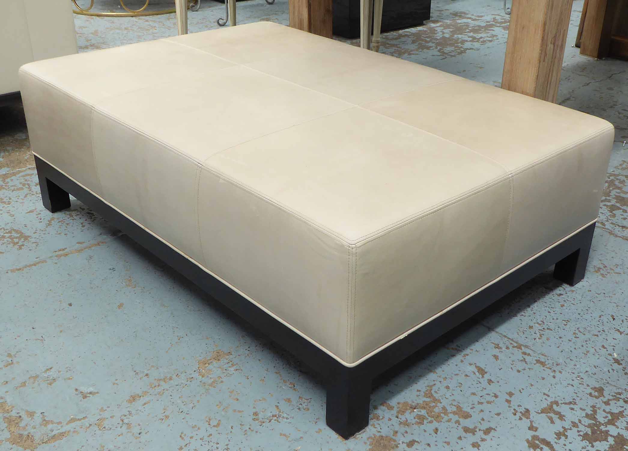 OTTOMAN, putty coloured material, leather stitched detail, 120cm W x 41cm H.