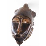 BAULE FACE MASK, carved and painted wood, 43cm H, together with a tall stand, 104cm H overall.