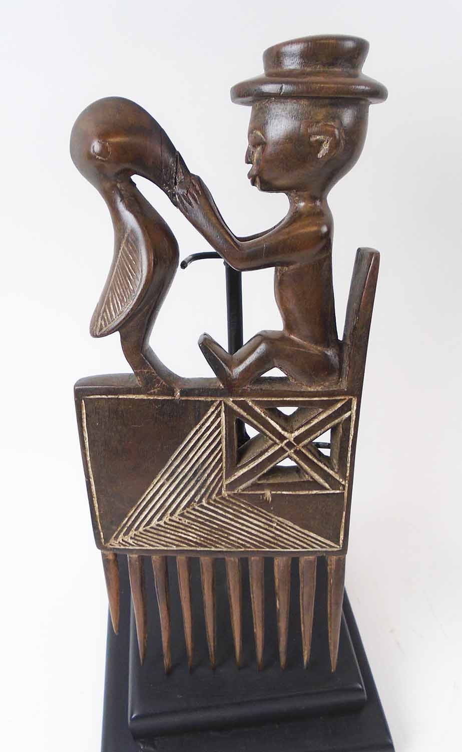 FOUR VARIOUS DECORATIVE COMBS, Cote d'Ivoire, carved wood, each approx. 27cm H, plus display stands. - Image 4 of 5