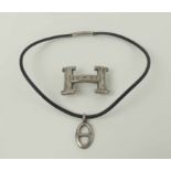 HERMES SILVER 'H' BUCKKLE, 5cm W, and a silver Hermes pendant.