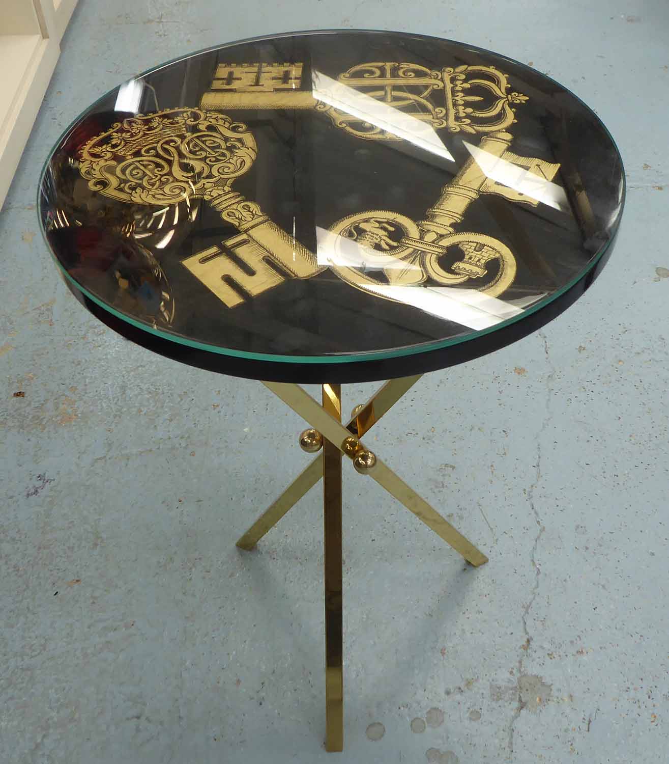 FORNASETTI 'KEYS' OCCASIONAL TABLE, lacquered top on brass base.