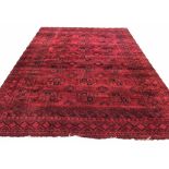 AFGHAN CARPET, 407cm x 300cm, rows of tribal guls onto a deep ruby field,