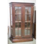 DISPLAY CABINET, hardwood with two glazed doors enclosing shelves, canted sides,