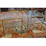 LOW OCCASIONAL TABLES, a pair, gilt metal framed, three tier, each with a square glass top,