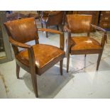 STUDIO ARMCHAIRS, a pair, early 20th century French, tan leather upholstered and splay supports.