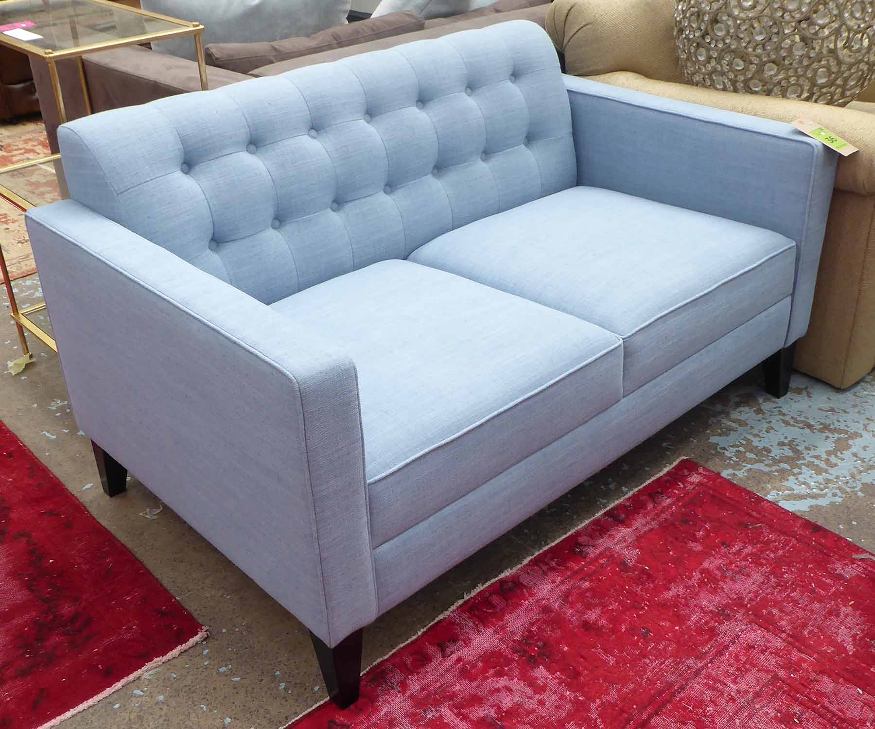 SOFA, two seater, upholsteed in light blue fabric, back with buttons on tapered dark wooden legs,