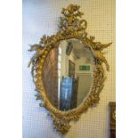WALL MIRROR, George III style oval giltwood with leaf, scroll, flowerhead and Ho ho bird decoration,