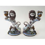 FAIENCE RAMPANT LION CANDLESTICKS, a pair, decorated in colours and bearing signature 'St.