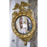 REGENCY CONVEX WALL MIRROR, the gilt wood surround with eagle cresting, 61cm W x 106cm H max.