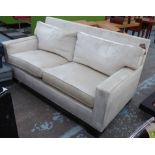 CONTEMPORARY SOFA, two seater, in an ivory fabric on square ebonised supports, 180cm L.