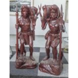 TRIBESMEN AFTER THE HUNT, a pair, carved wood in red lacquer finish, 91cm H.