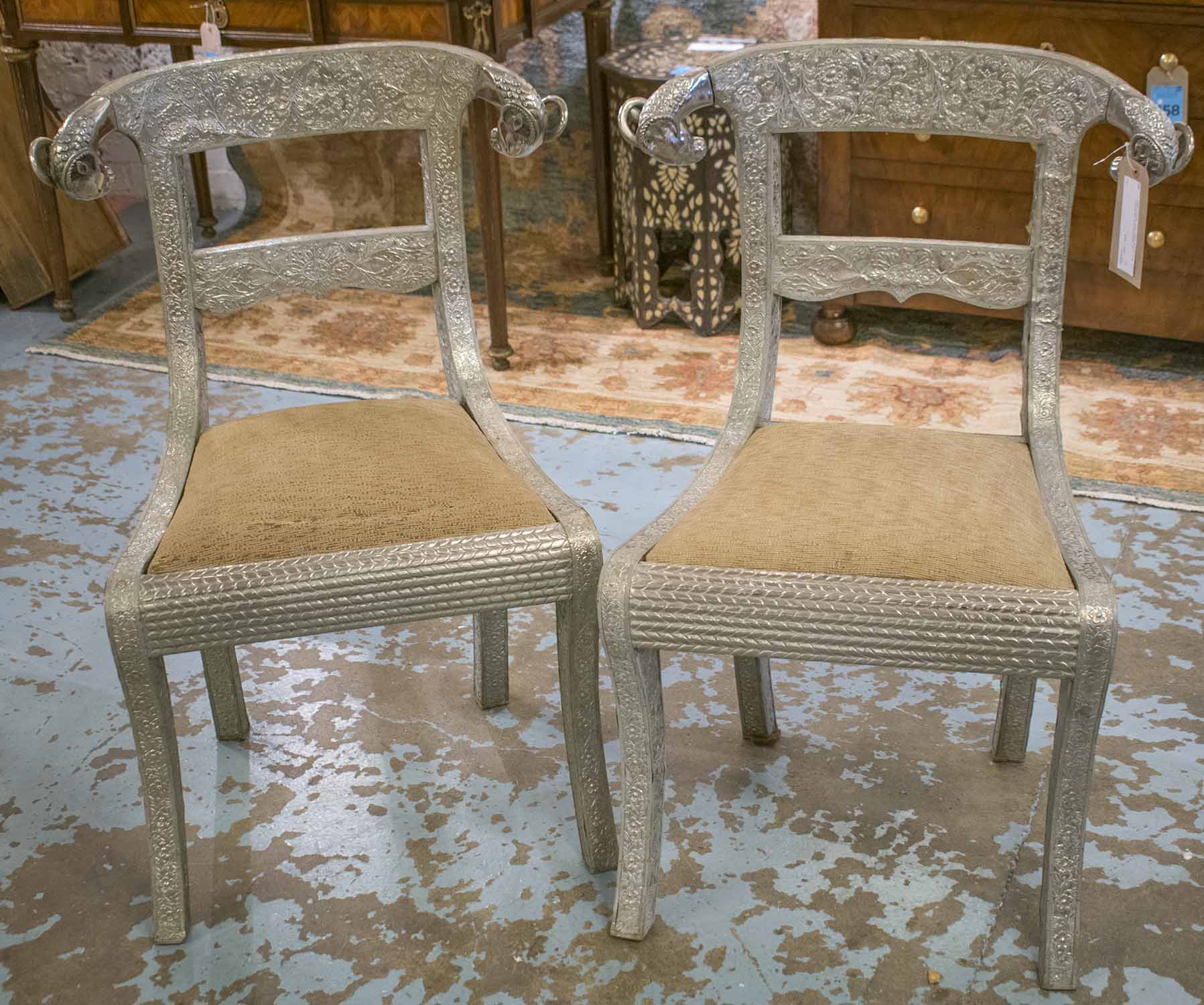 SIDE CHAIRS, a pair, Indian silvered metal covered with rams head backs.